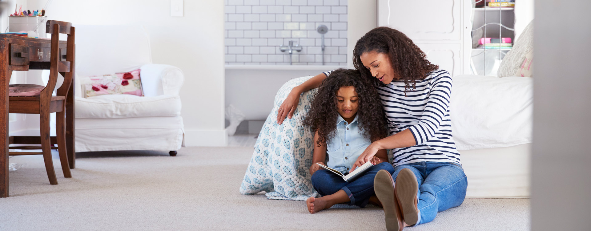 iStock-944580710-1920×750-XL Mother reading with daughter in comfortable home